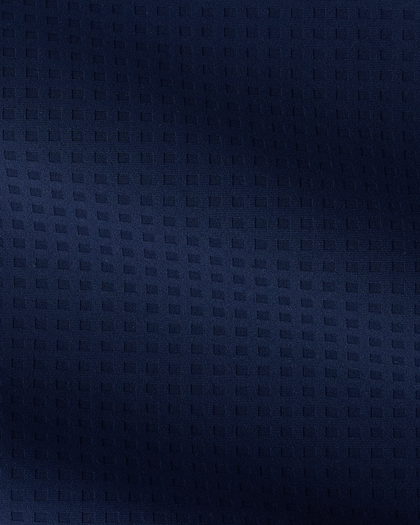 A close-up of a dark navy blue textured fabric with a subtle woven geometric pattern.