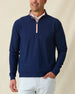 Men's Bel Air Quarter Zip in New Indigo, front model view featuring a navy long sleeve quarter zip pullover with a subtle textured fabric and pink contrast zip placket, layered over a white striped polo, styled with light gray pants