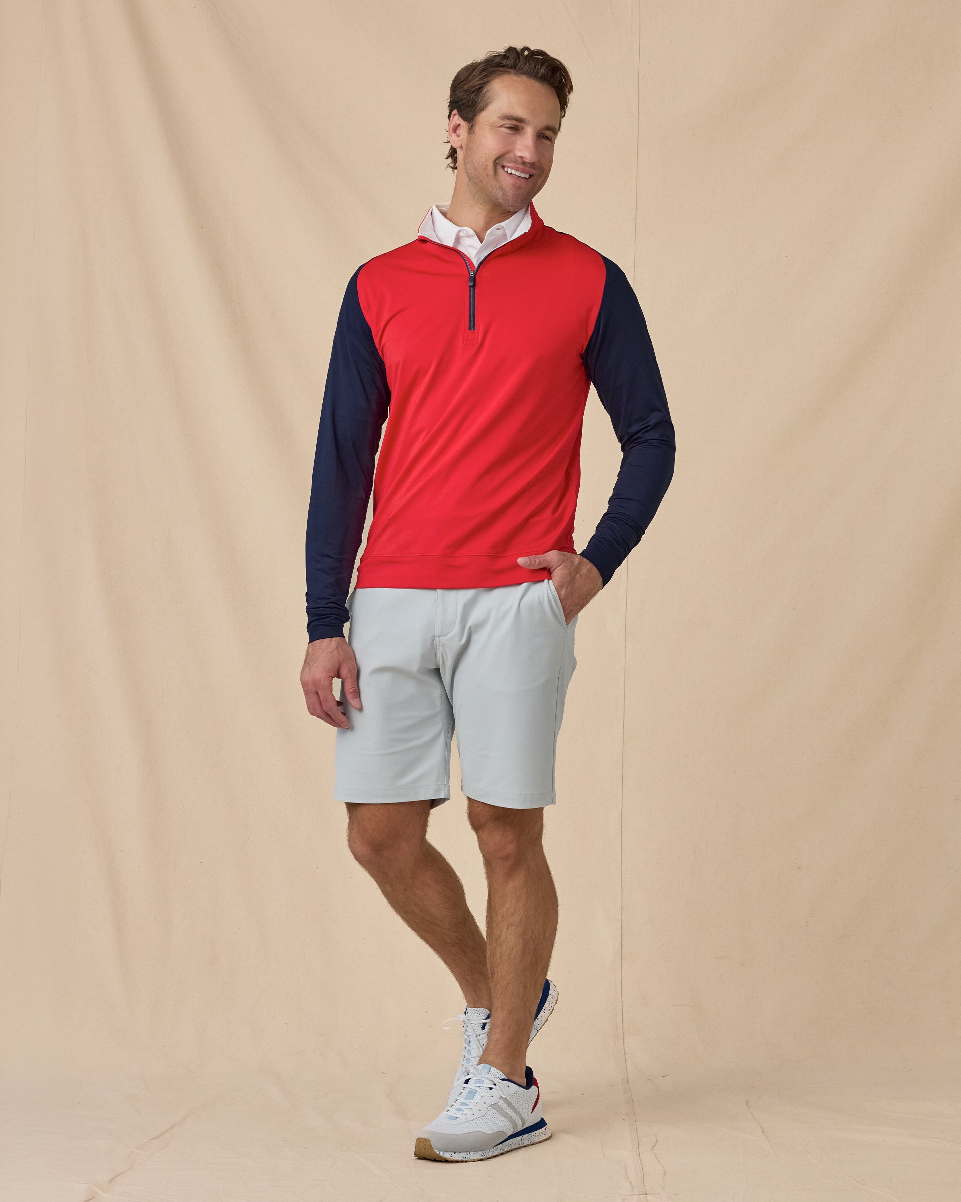 Men’s Falcon Quarter Zip in Flag Red with navy sleeves, styled full outfit view with light shorts layered over white polo