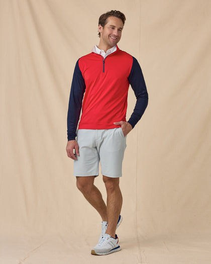 Men’s Falcon Quarter Zip in Flag Red with navy sleeves, styled full outfit view with light shorts layered over white polo