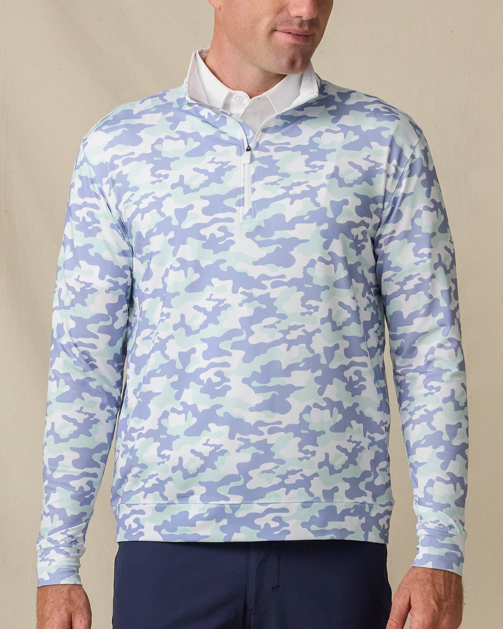 Model wearing the Arlington Quarter Zip in Blue Shade, featuring a soft blue and mint camouflage print with a quarter-zip neckline.
