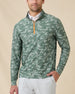 Model wearing the Arlington Quarter Zip in Dark Forest over a white polo, featuring a green camouflage print and orange zipper.