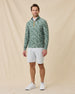 Model wearing the Arlington Quarter Zip in Dark Forest with white shorts and white golf shoes.