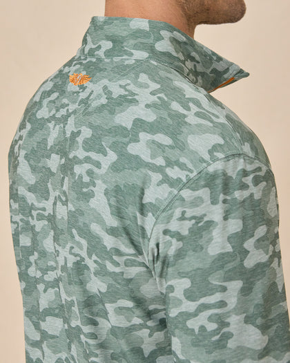 Close-up of the Arlington Quarter Zip in Dark Forest showing the camouflage print and orange embroidered logo below the collar.
