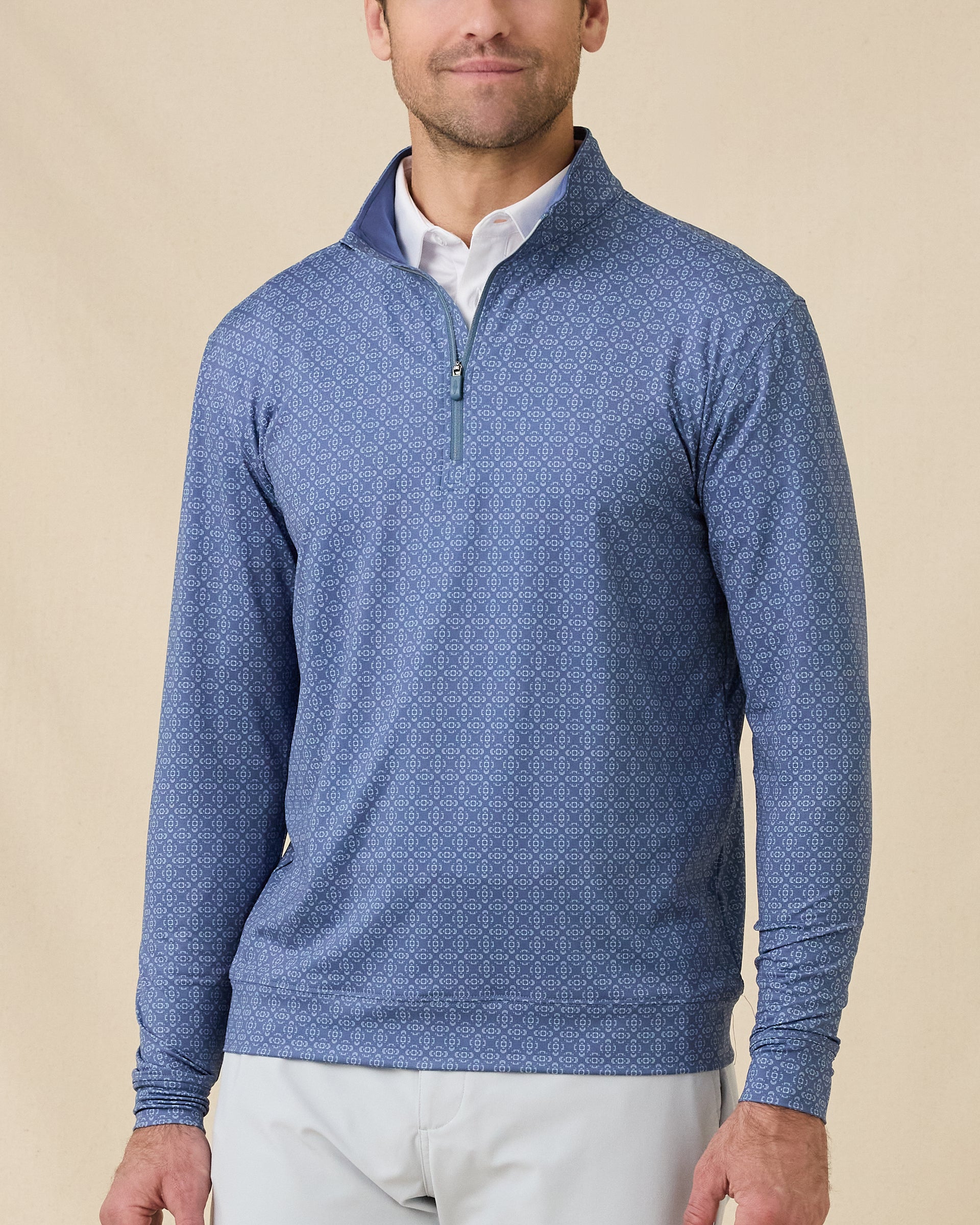 Front view of a man wearing the Mulholland Quarter Zip in Moonlight over a white polo, showing the allover geometric print and stand collar.