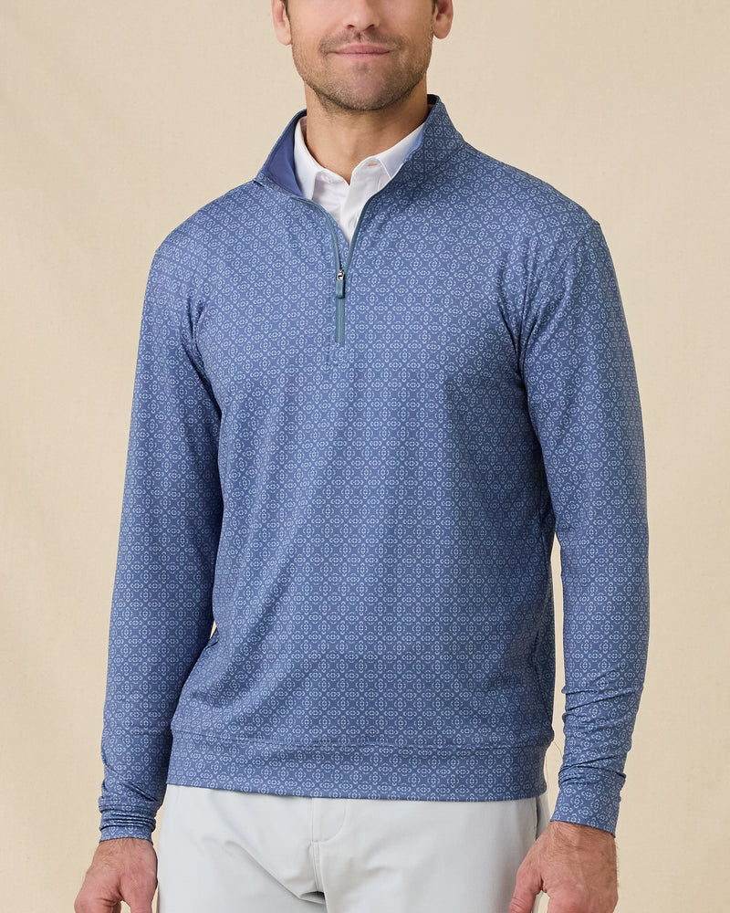 Front view of a man wearing the Mulholland Quarter Zip in Moonlight over a white polo, showing the allover geometric print and stand collar.