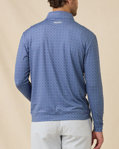 Back view of a man wearing the Mulholland Quarter Zip in Moonlight, showing the allover geometric print and embroidered logo below the back collar.