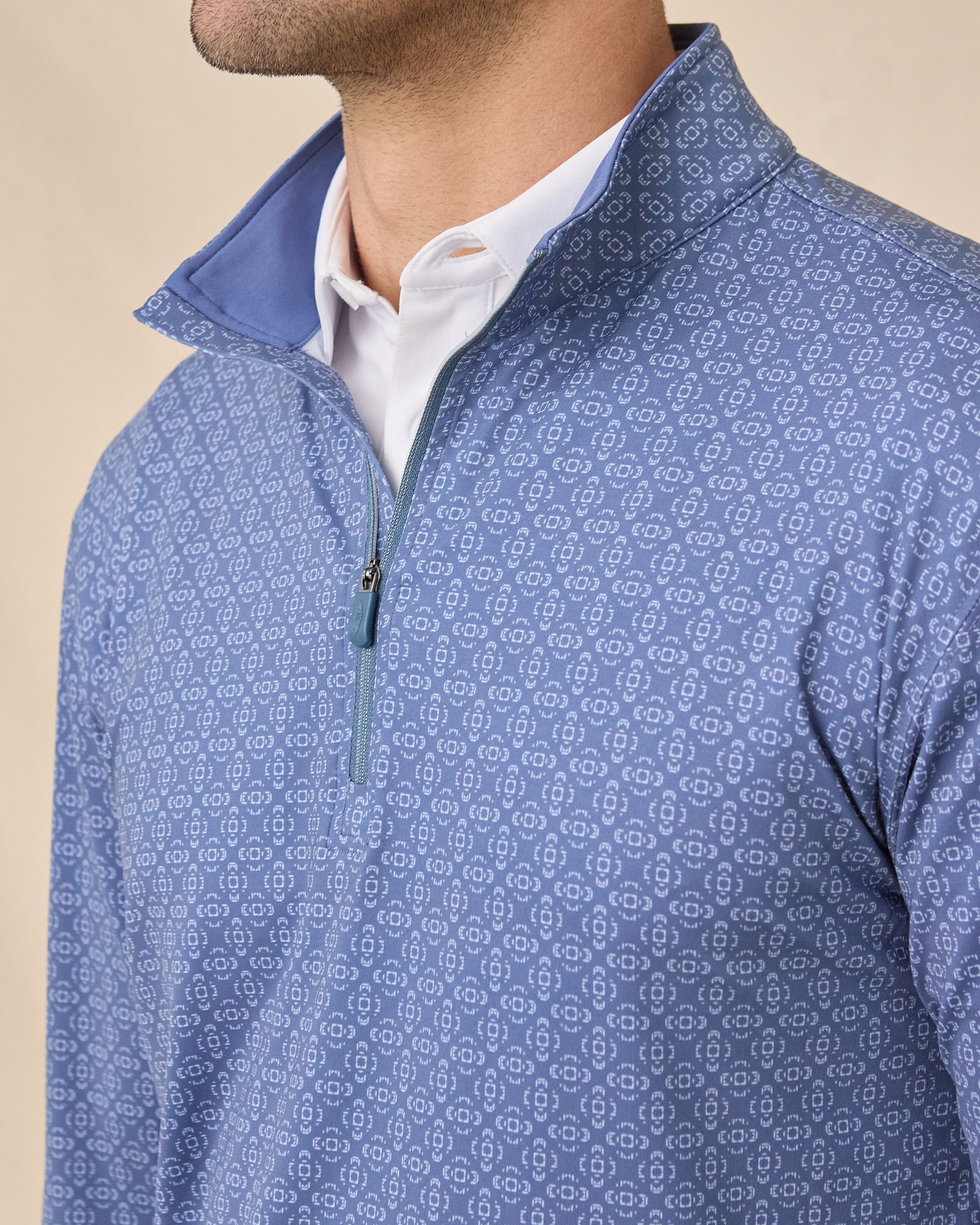 Close-up of the Mulholland Quarter Zip in Moonlight showing the geometric print, quarter-zip closure, zipper pull, and contrast blue inner collar.