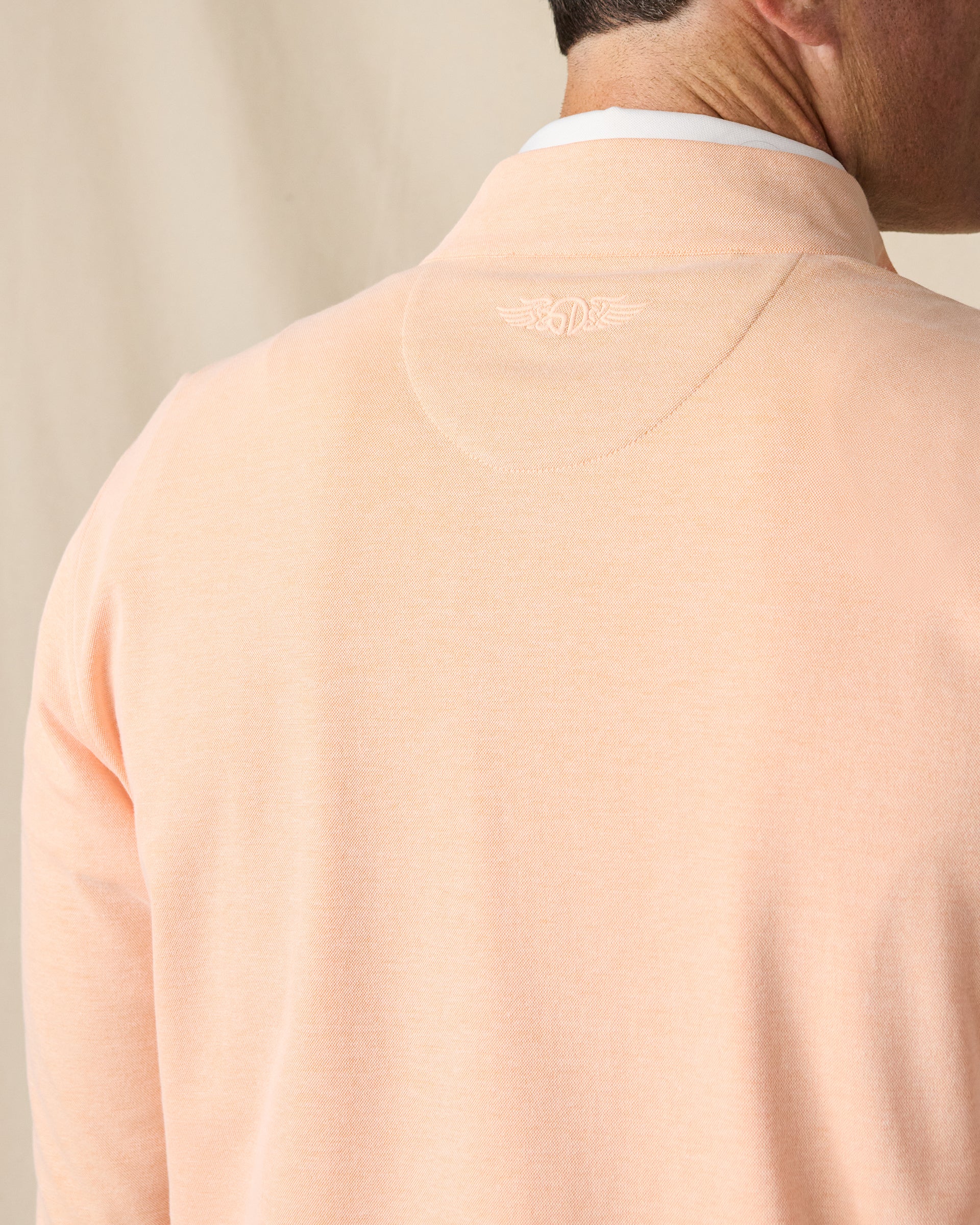 Close-up of the back of the Glendale Quarter Zip in Cantaloupe, highlighting the heathered fabric and tonal embroidered Straight Down logo below the collar.