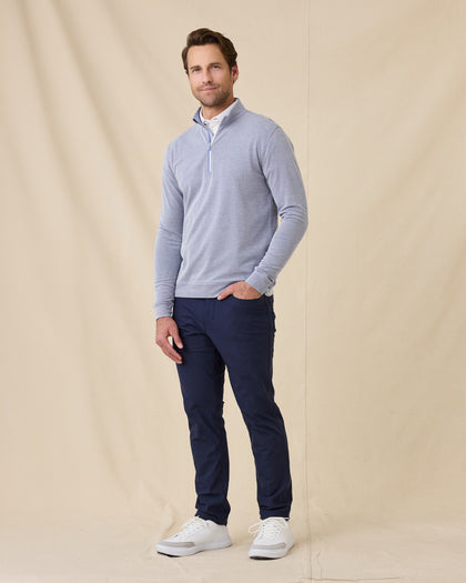 Model wearing the Glendale Quarter Zip in Tidal Blue paired with navy golf pants