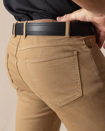 Men's Claremont Five Pocket Twill Pant in British Khaki, close-up detail view of the back patch pocket and waistband featuring warm tan twill fabric, styled with a black leather belt