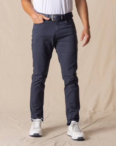 Men's Claremont Five Pocket Twill Pant in Ink, front on-model view featuring a dark navy twill fabric, styled with a white t-shirt, navy leather belt, and white shoes