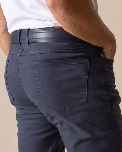 Men's Claremont Five Pocket Twill Pant in Ink, close-up detail view of the back patch pocket and waistband featuring dark navy twill fabric, styled with a navy leather belt with tan accent