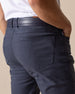 Men's Claremont Five Pocket Twill Pant in Ink, close-up detail view of the back patch pocket and waistband featuring dark navy twill fabric, styled with a navy leather belt with tan accent