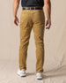 Men's Smithson Corduroy Pant in Bronze, back on-model view featuring a golden tan corduroy, styled with a black t-shirt, black leather belt, and white shoes