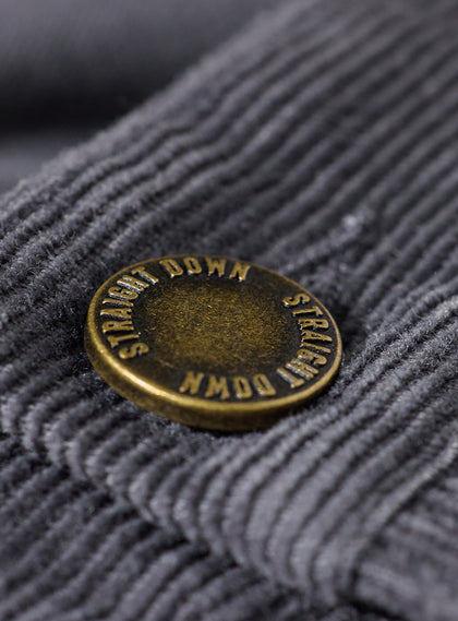 Men's Smithson Corduroy Pant in Walrus, close-up detail view of the antiqued brass Straight Down branded button against the charcoal gray fine wale corduroy fabric