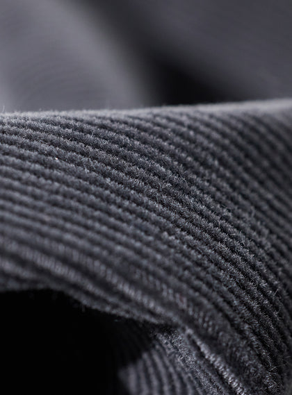 Men's Smithson Corduroy Pant in Walrus, macro detail view showcasing the rich texture and raised wale pattern of the charcoal gray corduroy fabric