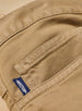 Men's Henderson 5 Pocket Pant in Bronze, close-up interior pocket detail featuring a woven logo tab and tonal topstitching