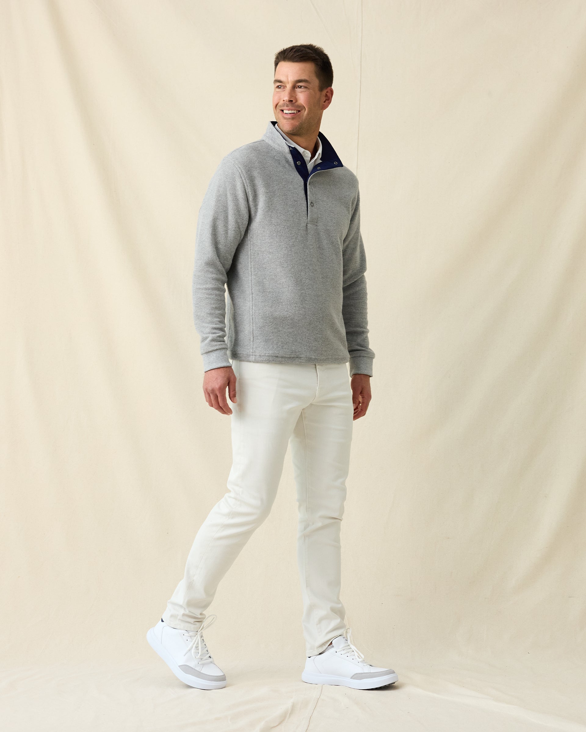 Men's Henderson 5 Pocket Pant in Vapor, full length side view on model featuring five-pocket styling, paired with a gray pullover, white polo, and white shoes