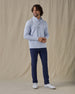 Men's Hollister Snap Placket Pullover in Powder, on model front full-length view featuring a light blue waffle-knit pullover with a snap button placket and stand collar paired with navy pants and white shoes