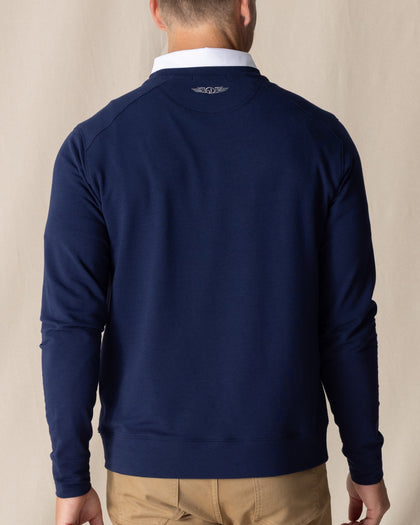 Men's Nathan 2.0 Crew in New Indigo, back view on male model showing embroidered logo at center back neck and ribbed hem, paired with khaki pants