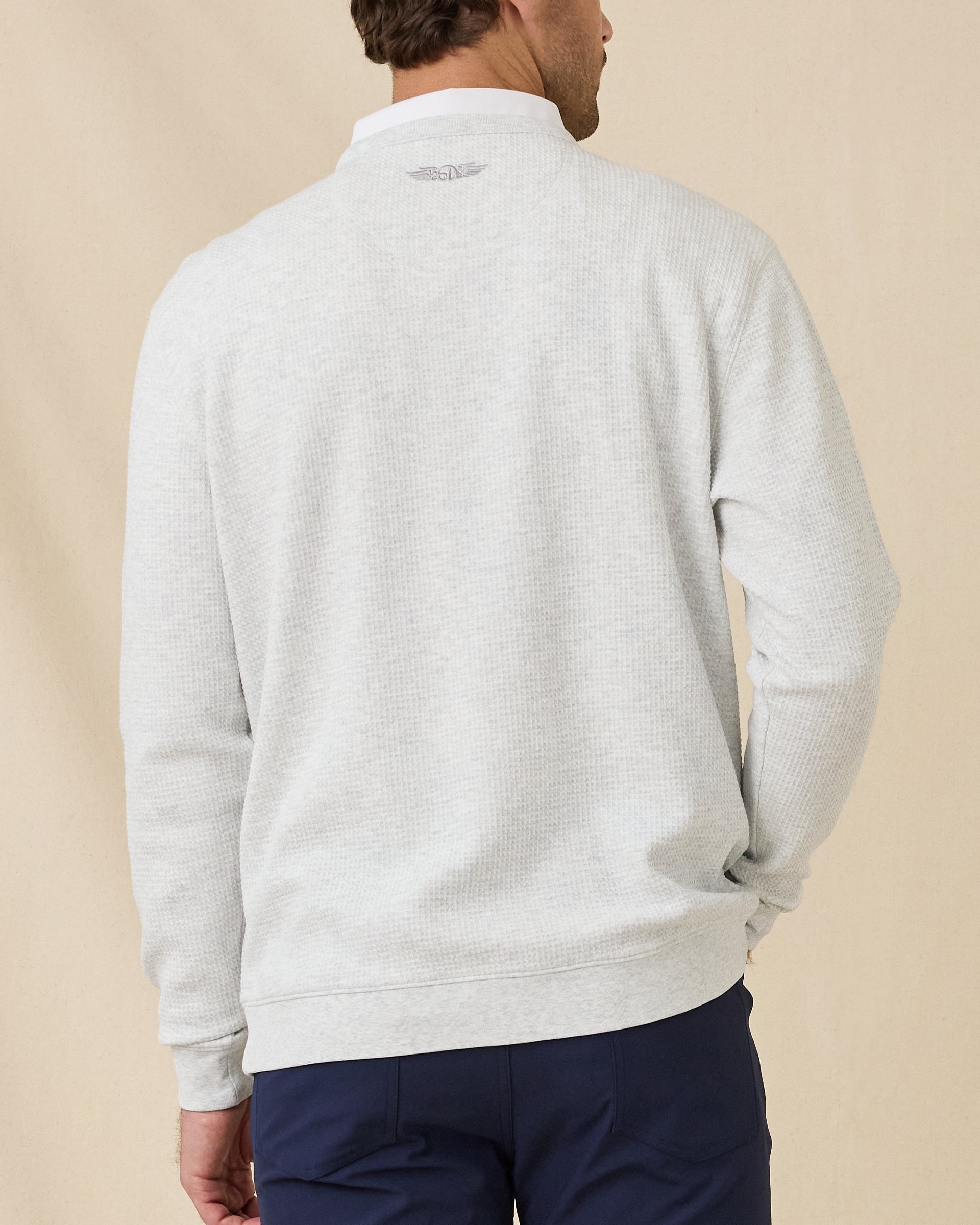 Model wearing the Hopkins Crew in Heather, showing the textured knit and embroidered logo below the back neckline.