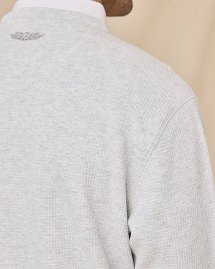 Close-up of the Hopkins Crew in Heather highlighting the textured knit, shoulder seam, and embroidered logo below the neckline.