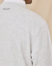 Close-up of the Hopkins Crew in Heather highlighting the textured knit, shoulder seam, and embroidered logo below the neckline.