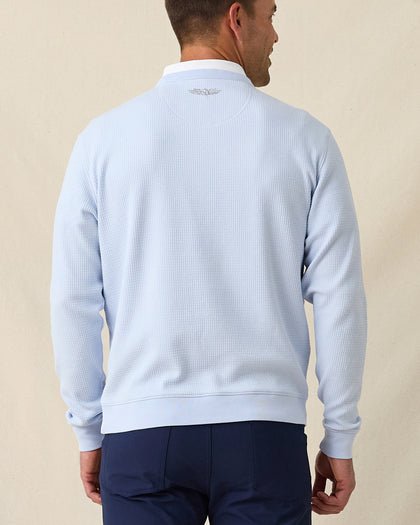 Back view of men’s light blue textured crewneck pullover with ribbed hem and cuffs, worn with navy pants.
