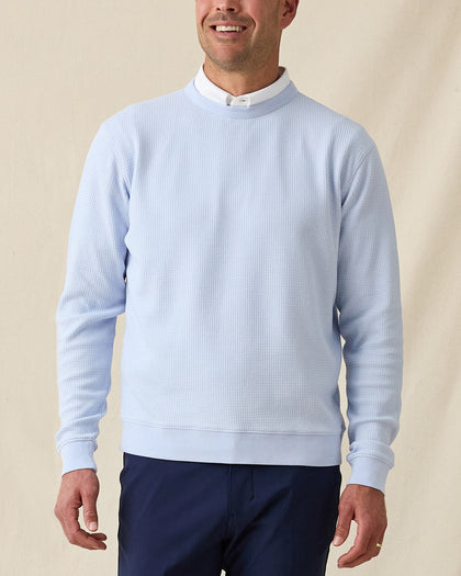 Men’s light blue long sleeve textured crewneck pullover worn over a white polo, paired with navy pants.