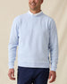Men’s light blue long sleeve textured crewneck pullover worn over a white polo, paired with navy pants.
