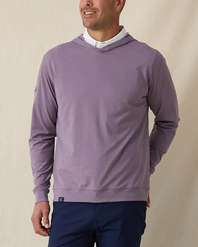 Man wearing purple pullover hoodie over a white polo styled with navy pants