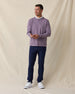Man wearing purple pullover hoodie over a white polo styled with navy pants and white shoes