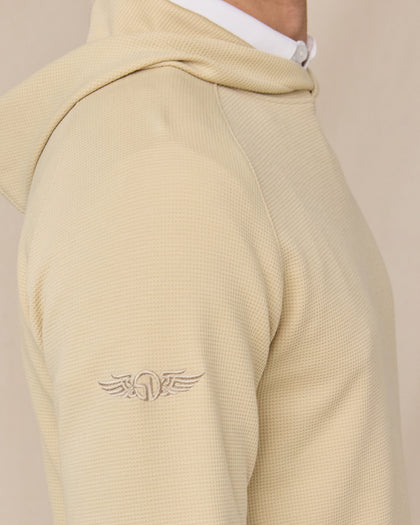Close-up of the Gridlock Hoodie in Sandstorm highlighting the waffle knit texture, raglan shoulder seam, and embroidered sleeve logo.