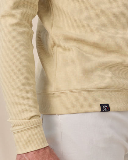 Close-up of the Gridlock Hoodie in Sandstorm showing the waffle knit texture, banded hem, cuff, and woven logo label.