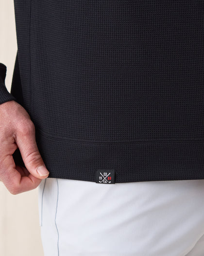 Men’s Gridlock Hoodie in black, close-up hem logo detail