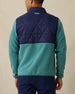 Men's Okemo Hybrid Fleece Jacket in Sage, back view on model featuring a navy quilted upper body with a sage fleece lower body and sleeves, with Straight Down logo embroidered at upper back