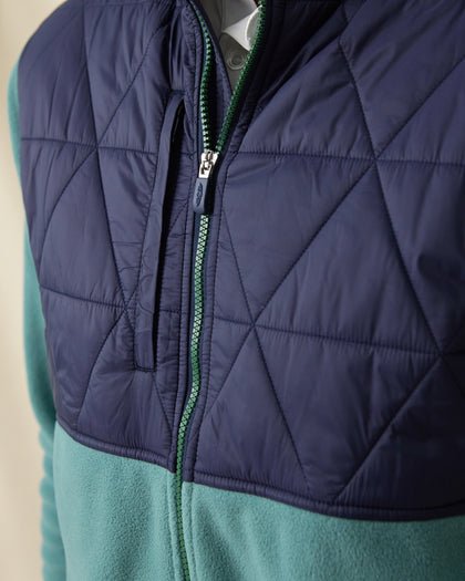 Men's Okemo Hybrid Fleece Jacket in Sage, close-up front view highlighting the navy quilted upper body, chest pocket, and full zip closure with green zipper detail