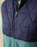Men's Okemo Hybrid Fleece Jacket in Sage, close-up front view highlighting the navy quilted upper body, chest pocket, and full zip closure with green zipper detail