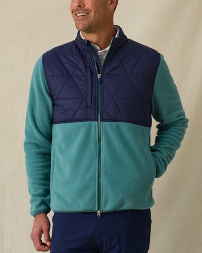 Men's Okemo Hybrid Fleece Jacket in Sage, front view on model featuring a navy quilted upper body with a sage fleece lower body and sleeves, paired with navy pants