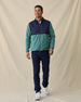 Men's Okemo Hybrid Fleece Jacket in Sage, full length front view on model featuring a navy quilted upper body with a sage fleece lower body and sleeves, paired with navy pants and white shoes