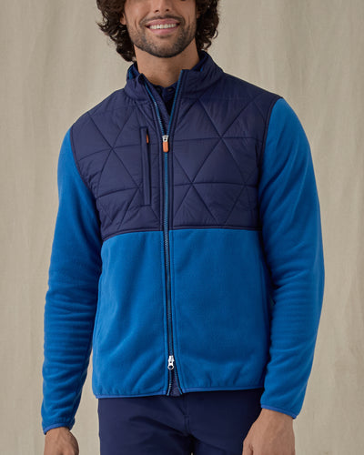 Men's Okemo Hybrid Fleece Jacket in Bering, front view on model featuring a navy quilted upper body with royal blue fleece lower body and sleeves, worn with navy pants