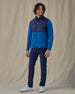 Men's Okemo Hybrid Fleece Jacket in Bering, full front view on model featuring a navy quilted upper body with royal blue fleece lower body and sleeves, worn with navy pants and white golf shoes