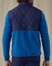 Men's Okemo Hybrid Fleece Jacket in Bering, back view on model featuring a navy quilted upper back with royal blue fleece lower body and sleeves with the Straight Down logo embroidered at the upper back, worn with navy pants