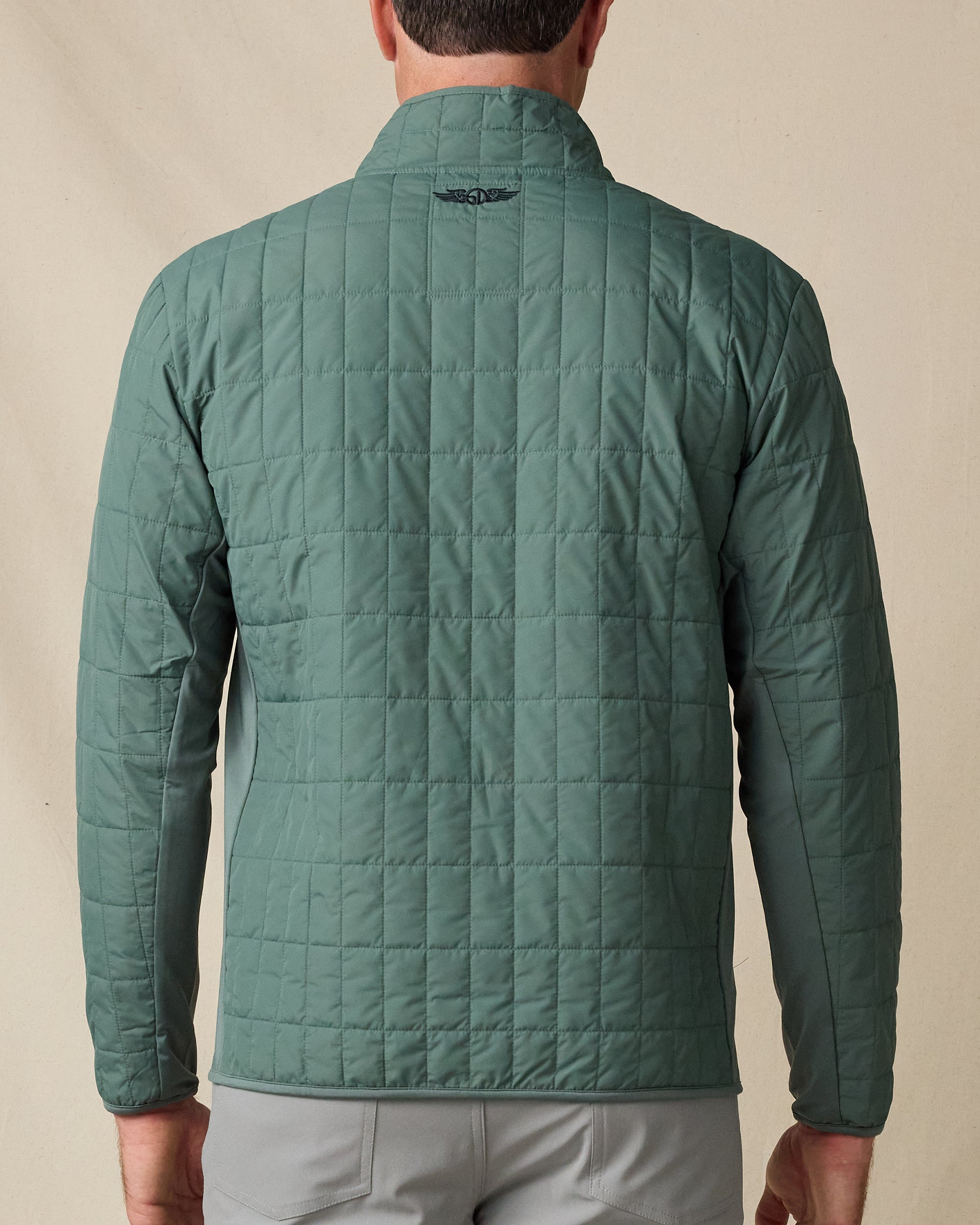 Rear view of the Big Sky Quilted Jacket in Dark Forest, showing the all-over quilted construction and embroidered logo below the collar.