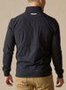 Men's Harding Hybrid Quarter Zip in Black, back view on male model showing white embroidered logo at center back neck and dual-fabric paneling, paired with khaki pants
