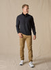 Men's Harding Hybrid Quarter Zip in Black, full-length front view on male model styled with khaki pants and white shoess against a neutral linen backdrop