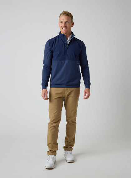 Men's Harding Hybrid Quarter Zip in New Indigo, full-length front view on male model styled with khaki pants and white golf shoes against a light grey background