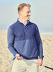 Men's Harding Hybrid Quarter Zip in New Indigo, lifestyle photo of male model holding a golf club on a sandy beach, layered over a white polo