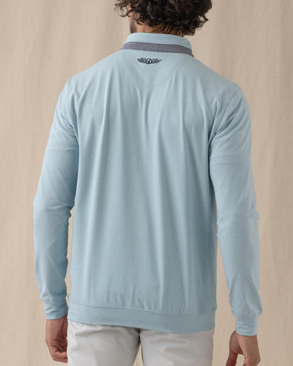 Men's Cimarron Quarter Zip in Delphinium, back view on male model showing embroidered logo at center back neck and grey heathered collar, paired with white pants